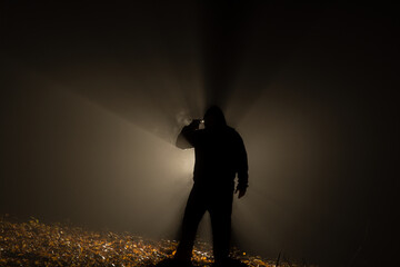 Suicide armed silhoulette man in dark forest at backlight