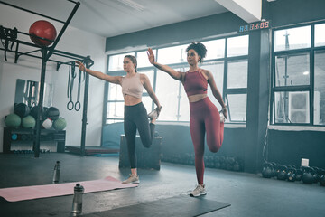 Obraz na płótnie Canvas Balance, stretching and friends with women in gym for training, workout and exercise. Teamwork, health and personal trainer with girl and muscle warm up for wellness, sports and fitness goals