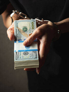 Dollar bills in handcuffed hands