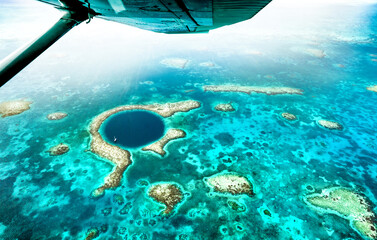 Aerial panoramic view of The Great Blue Hole - Detail of Belize coral reef from airplane excursion - Wanderlust and travel concept with nature wonders on azure vivid filter - 563989043