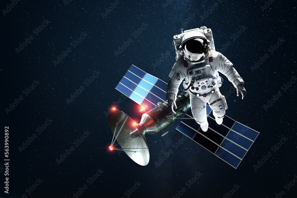 Wall mural astronaut in a white spacesuit in space on the background of a satellite. exploration of space and o