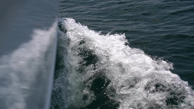 The bow of the white yacht cuts the waves. Slow motion