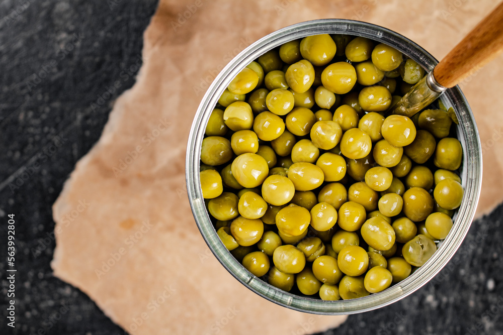 Sticker An open tin can with canned green peas on paper. 