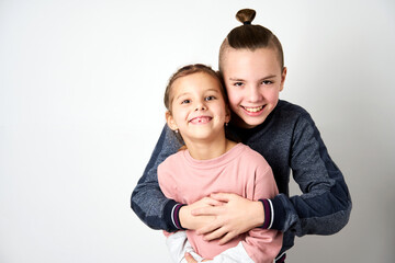 Boy and girl hugging each other on white background