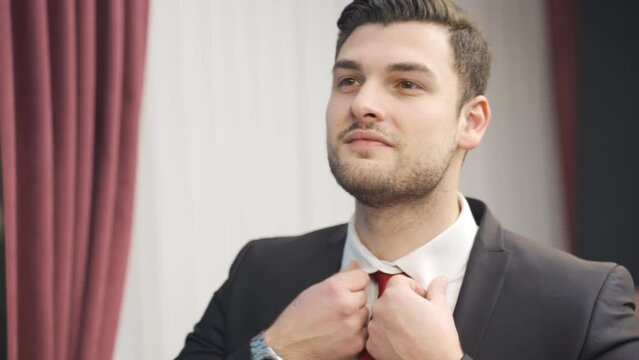 Charismatic businessman in suit looking at himself in mirror and confident.
Young business man looking at himself in the mirror at home happy, smug, likeable and cool.
