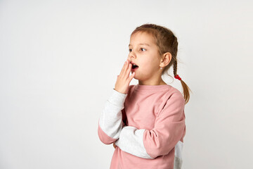 Little cute girl picking her nose, white background
