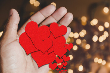Hands holding Red hearts, in the background of BOKEH, concept of world day of love and friendship, Valentine's Day.