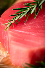 Raw tuna with a sprig of rosemary. 