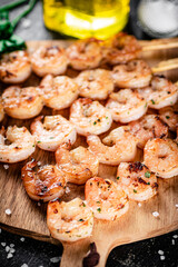 Grilled shrimp on a wooden cutting board. 