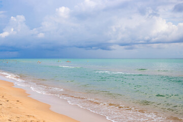 The sandy shore of the Black Sea on a summer day. The sea and the sky with clouds.