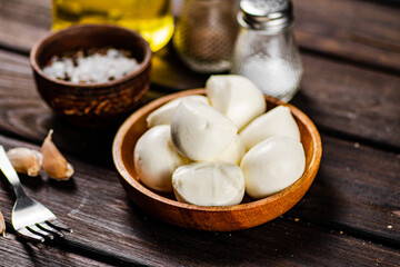 Mozzarella cheese with garlic. On a wooden background.