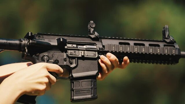 Closeup of a gun carbine during shooting, ejecting empty bullet casings. High quality 4k footage