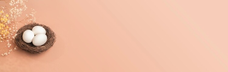 Eggs on a beige background.  Nest containing three egg. Minimal Easter concept with copy space for text.  