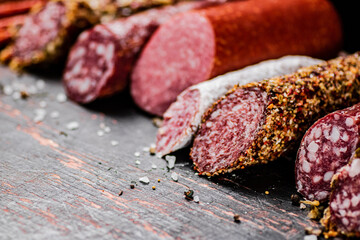 Various salami sausage on the table in a row. 