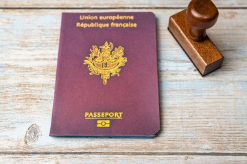 French passport and stamp on wooden background. Safe journey with necessary documentation. Top...