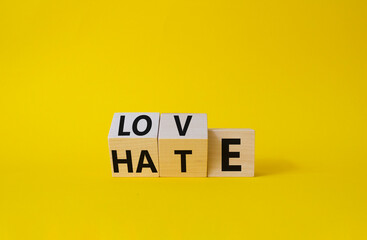 Love vs Hate symbol. Wooden cubes with words Hate and Love. Beautiful yellow background. Valentines Day and Love vs Hate concept. Copy space