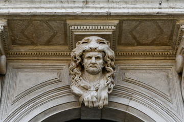 Close-up of a sculpture depicting Hercules with the skin of the Nemean lion above the front door of an ancient palace in Campo San Polo, Venice, Veneto, Italy
