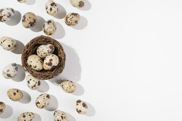 Quail eggs on a white background.  Nest containing three egg. Minimal Easter concept. Natural farm products
