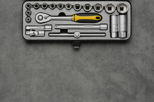 Tool kit for the car repair. Ratchet and bits tool kit. Socket wrench and ratchet heads. Equipment for auto mechanic on gray background. Tools for car repair at a service station. Top view, flat lay.
