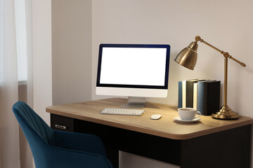 Comfortable workplace at home. Modern computer with blank screen and lamp on wooden desk. Mockup for design