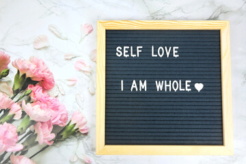 Grey letter board with phrase I am whole, self love, self care on natural background. Mindfulness lifestyle, mental health. Aspiration and supportive sentence