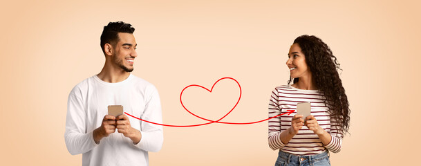 Romantic Arab Couple Holding Smartphones Connected With Drawn Red Heart Shape String