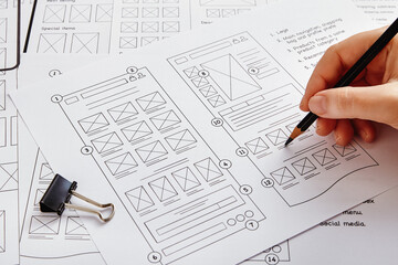 Web design project concept. Close up photo of a UX designer working on website project with a large...