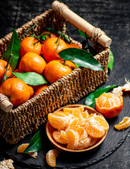Ripe tangerines with leaves in a basket. 