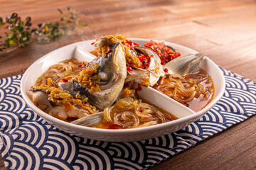 Spicy chilli Mao Xiang Big Fish Head with Fish Pork, Bean Pork with Potato Flour served dish isolated on wooden table top view of Hong Kong food