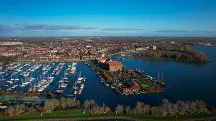 Historic harbor city of Hoorn, view of old buildings and sailing ships in the marina. Early morning in winter, aerial view from a high angle