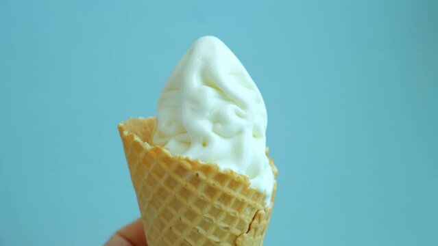 sugar cone with melted ice cream on a blue background