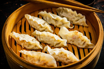Fragrant gyoza dumplings in a bamboo steamer. 