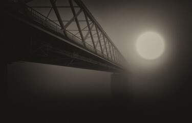 Dark landscape showing the bridge in the fog at sunset in sepia tones