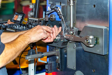 Hands working on manufacturing machine