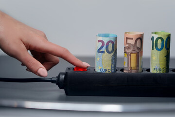 black power strip and euro banknotes, which symbolize the huge increase of electricity prices in...