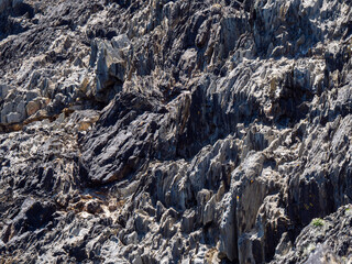 A geological strata, background. Stone texture, full frame. Brown and gray rock formation