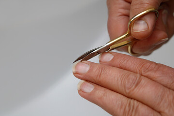 Fingernägel schneiden mit einer Nagelschere - obrazy, fototapety, plakaty