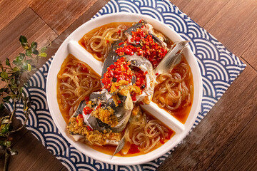 Spicy chilli Mao Xiang Big Fish Head with Fish Pork, Bean Pork with Potato Flour served dish isolated on wooden table top view of Hong Kong food