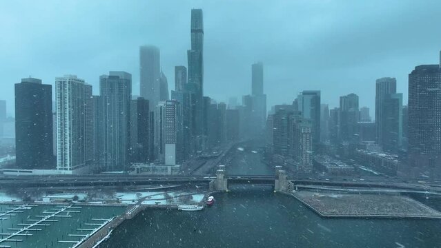 Drone aerial view of Chicago skyline from Lake Michigan flying over Chicago River snowing in winter on cloudy day