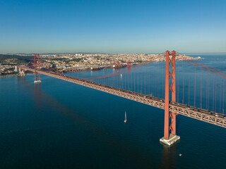 The 25 April bridge (Ponte 25 de Abril) located in Lisbon, Portugal, crossing the Targus river. Drone.