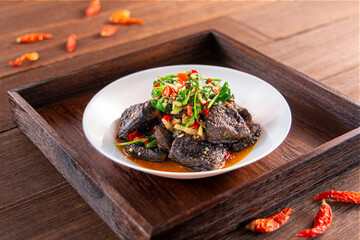Spicy chilli stinky tofu served dish isolated on wooden table top view of Hong Kong food