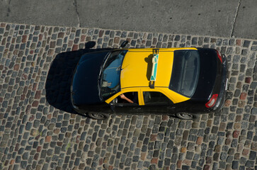taxi from the city of buenos aires driving through a typical cobbled street of the old city. black...