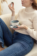 Woman drinks tea or coffee with sweets. Natural. Soft focus