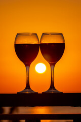 Two glasses of wine and tropical sea sunset