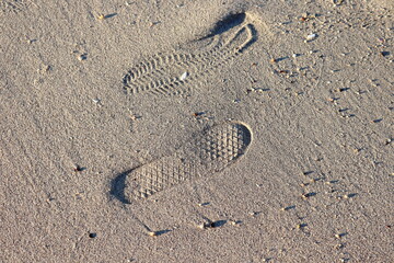 Footprints and shoe prints on the sand