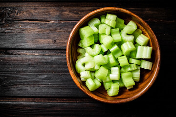 Sliced fresh celery. On a dark wooden background.