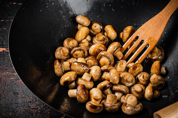 Small fried mushrooms in a frying pan. 