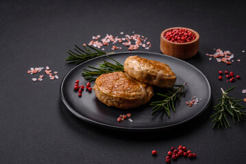 Grilled meatballs with spices and herbs or crepinette on a black plate