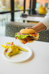 person holding bacon cheeseburger