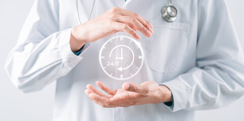 Doctor in a white coat uniform holding 24/7 service icon for assistance patient when accident or emergency, Medical call center service without interruption day and night.
